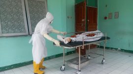 Petugas pemulasaran jenazah membawa jasad A untuk dimandikan di Ruang Jemazah RSUD TC Hillers Maumere, Kamis (20/10)