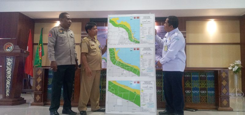 Kepala Stasiun Geofisika Kupang Margiono Peta Bahaya Tsunami 3 Kelurahan di Kota Maumere kepada Asisten Administrasi Umum Setda Sikka Robertus Ray, Selasa (6/12) di Aula Lantai 3 Kantor Bupati Sikka