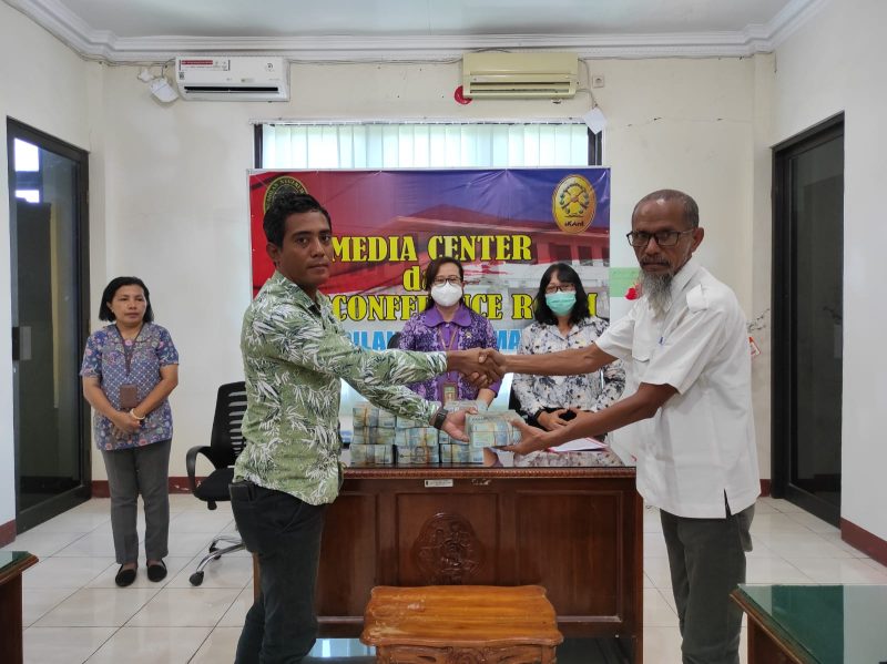 Dedy Yafet Nggi (kiri), termohon eksekusi dari AJB Bumiputera menyerahkan uang sejumlah Rp 1,5 miliar kepada Viktor Nekur selaku Kuasa Para Pemohon Eksekusi dari Kopdit Pintu Air, Kamis (1/12)