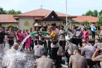 Kapolres Sikka AKBP Nelson Filipe Diaz Quintas sedang menyiram anggota Polres Sikka dan Yon B Brimob Maumere yang mendapat kenaikan pangkat, Senin (2/1)