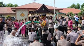 Kapolres Sikka AKBP Nelson Filipe Diaz Quintas sedang menyiram anggota Polres Sikka dan Yon B Brimob Maumere yang mendapat kenaikan pangkat, Senin (2/1)