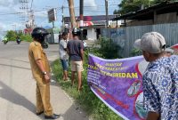 Lurah Nangalimang bersama warga mencopot spanduk provokatur di perempatan Jalan Lingkar Luar, Senin (9/1) (foto: istimewa)