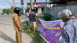 Lurah Nangalimang bersama warga mencopot spanduk provokatur di perempatan Jalan Lingkar Luar, Senin (9/1) (foto: istimewa)