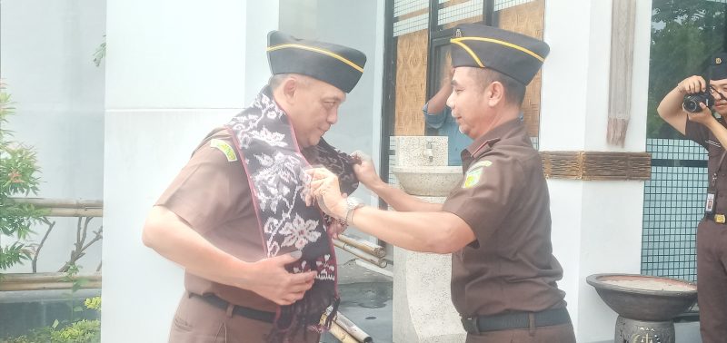 Kepala Kejaksaan Negeri Sikka Fatoni Hatam mengalungkan selendang adat Sikka ke Aspidum Kejati NTT Muhamad Ihsan, Selasa (21/2)