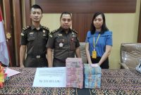 Istri tersangka Laurensius Gregorius menyerahkan uang ganti rugi kasus dugaan korupsi BTT, Senin (20/2)