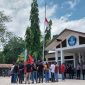 Demonstran GMNI Sikka menurunkan bendera hingga setengah tiang di Kantor Dinas PKO Sikka, Senin (16/10) 