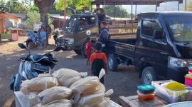 Petugas SatPol PP Sikka dari atas mobil dalmas membaca pengumuman penghentian aktifitas Pasar Wuring, Jumat (1/12) 