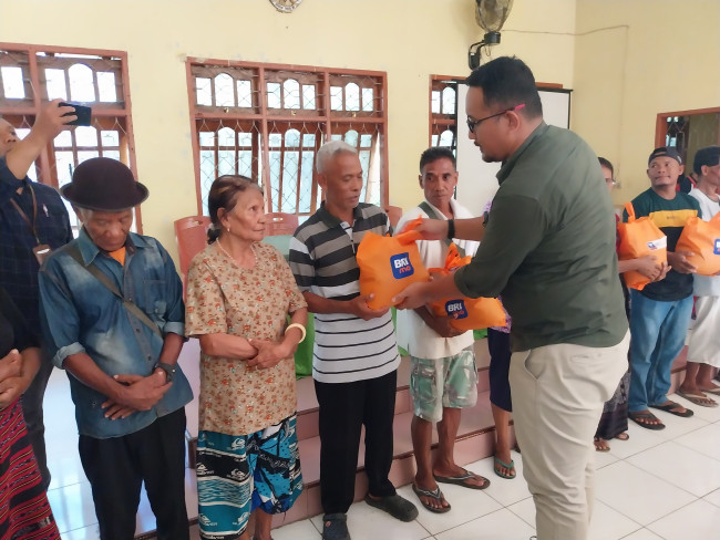 Pimpinan Cabang BRI Maumere Heru Pratomo menyerahkan bantuan paket sembako kepada warga Desa Magepanda, Jumat (22/12)