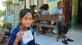 Maria Yuliana Tanga, korban gigitan anjing liar menunjukkan kartu pemeriksaan kesehatan saat antri VAR di Puskesmas Palue, Selasa (23/4)