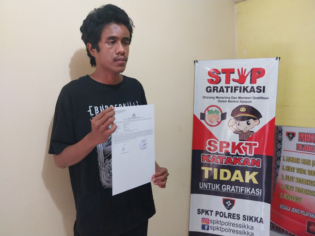 Korban penganiayaaan memperlihatkan dokumen laporan kepolisian, Selasa (25/6)