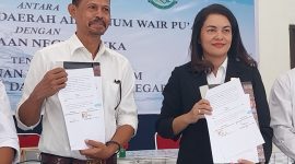 Direktur Utama Perumda Air Minum Wair Pu'an Fransiskus Laka dan Kepala Kejaksaan Negeri Sikka Henderina Malo memperlihatkan Kesepakatan Bersama Bidang Perdata dan TUN di Aula Sekretariat FKUB Sikka, Rabu (9/10)