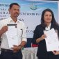 Direktur Utama Perumda Air Minum Wair Pu'an Fransiskus Laka dan Kepala Kejaksaan Negeri Sikka Henderina Malo memperlihatkan Kesepakatan Bersama Bidang Perdata dan TUN di Aula Sekretariat FKUB Sikka, Rabu (9/10)