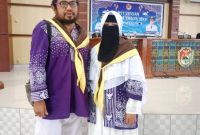 Rudi Susanto pose bersama istri saat acara pelepasan jemaah calon haji pada Mei 2025 