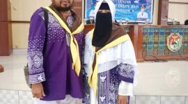 Rudi Susanto pose bersama istri saat acara pelepasan jemaah calon haji pada Mei 2025 