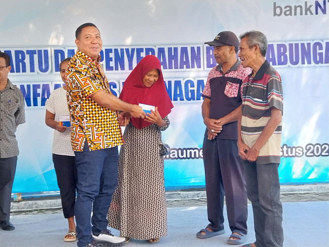 Bupati Sikka Juventus Prima Yoris Kago menyerahkan secara simbolis buku tahungan Bank NTT kepada penerima bantuan Jaminan Sosial, Sabtu (9/8)