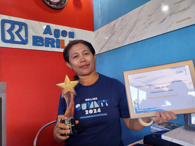 Owner Agen BRILink Gratia Petra Adolorata Mado memperlihatkan piala dan piagam pengharhaan sebagai Agen BRILink Loyalitas Terbaik se-Indonesia Tahun 2024, Jumat (15/8)