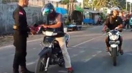 Personil Brimob Maumere membagikan bendera Merah Putih menjelang HUT ke-80 Kemerdekaan RI, Minggu (3/8)