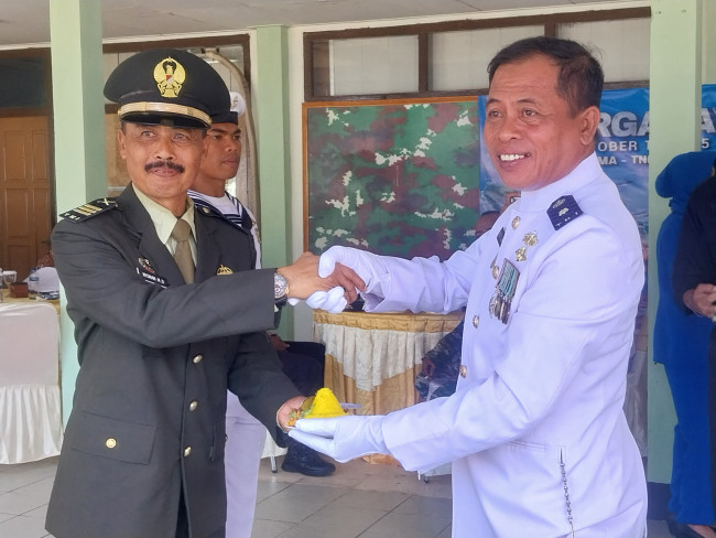 Palaksa Lanal Maumere Mayor Laut (T) Nono Sumarno menyerahkan tumpeng HUT ke-80 TNI kepada prajurit tertua Kapten Inf Nyoman Minggu Diana, Minggu (5/10)