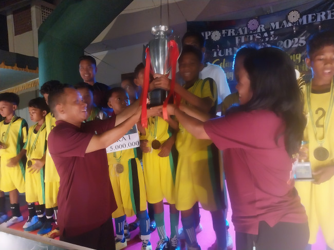 Kepala SMPK Frater Maumere Frater Maria Sebastianus BHK beraama Ketua Panitia Spater Futsal Cup 2025 Oktaviana Nona Yeni menyerahkan Piala Bergilir Spater Futsal kepada SDN Ona Nangahure, Senin (20/10)