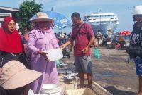 Maria Nona Saidah sedang melayani pembelian ikan dinTPI Alok, Jumat (24/10)