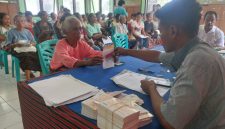 Seorang penerima PKH menerima buku rekening BRI dari pendamping PKH, Jumat (24/10)