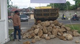 Ivan Baba Djoedye menyaksikan dump truk menurunkan batu di depan pintu gerbang DPRD Sikka, Kamis (30/10)