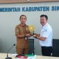 Deputi BPJS Kesehatan Wilayah XI Mangisi Raja Simarmata menyerahkan UHC Award kepada Sekda Sikka Adrianus Firminus Parera, Senin (2/2)