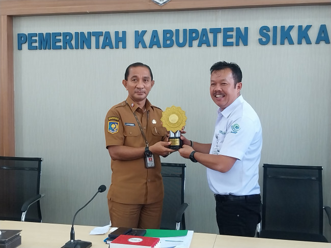 Deputi BPJS Kesehatan Wilayah XI Mangisi Raja Simarmata menyerahkan UHC Award kepada Sekda Sikka Adrianus Firminus Parera, Senin (2/2)