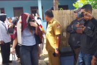 Salah seorang LC menutup wajah saat hendak ke Bandara Frans Seda, Senin (23/2)