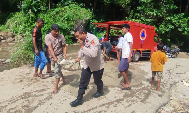 Camat Tana Wawo John Oriwis terlibat kerja swadaya memperbaiki jembatan yang putus diterjang banjir bandang, Selasa (23/3)