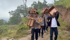 Kapolsek Paga bersama jajaran dan Camat Tanawawo menggotong kursi bantuan untuk SMP Negeri 048 Sa Ate Gaikiu, Sabtu (9/5)