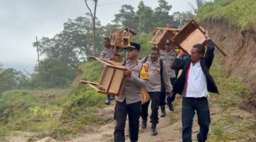 Kapolsek Paga bersama jajaran dan Camat Tanawawo menggotong kursi bantuan untuk SMP Negeri 048 Sa Ate Gaikiu, Sabtu (9/5)
