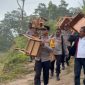 Kapolsek Paga bersama jajaran dan Camat Tanawawo menggotong kursi bantuan untuk SMP Negeri 048 Sa Ate Gaikiu, Sabtu (9/5)