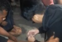 Seorang terduga pelaku sedang membuka plastik bening yang diduga narkotika jenis sabu, Rabu (6/5) malam 