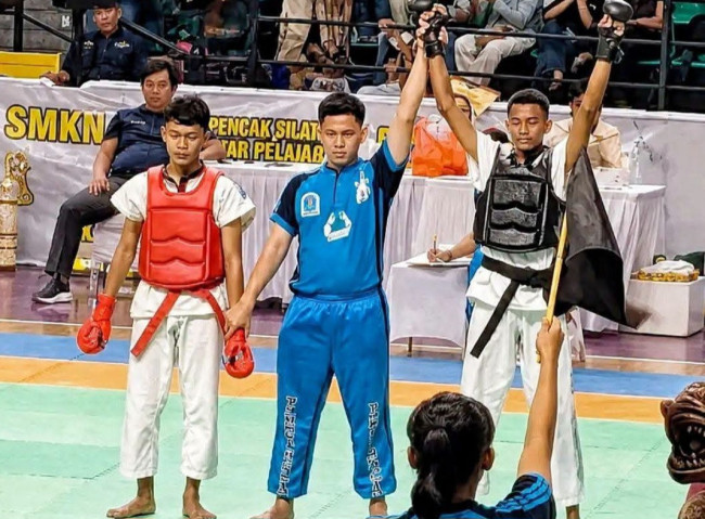 Jello Sadipun (ban hitam) ditunjuk sebagai pemenang pada Final Tarung Bebas Putra Kelas 46,1-49 kg di Kejurnas Tarung Derajat Pelajar BHS Cup III Tahun 2026 yang digelar di GOR CLS Surabaya, Minggu (30/8)