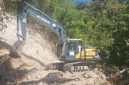 Sebuah exavator sedang melakukan pembersihan material longsor akibat gempa bumi tektonik di wilayah Kecamatan Palue