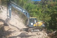 Sebuah exavator sedang melakukan pembersihan material longsor akibat gempa bumi tektonik di wilayah Kecamatan Palue