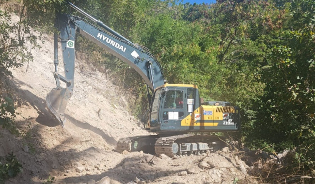 Sebuah exavator sedang melakukan pembersihan material longsor akibat gempa bumi tektonik di wilayah Kecamatan Palue