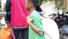 Seorang anak kecil ikut mengambil bantuan di Posko Logistik
