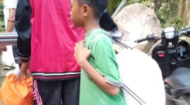 Seorang anak kecil ikut mengambil bantuan di Posko Logistik