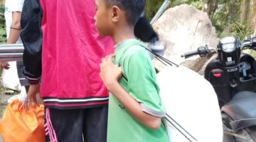 Seorang anak kecil ikut mengambil bantuan di Posko Logistik
