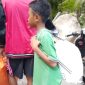 Seorang anak kecil ikut mengambil bantuan di Posko Logistik